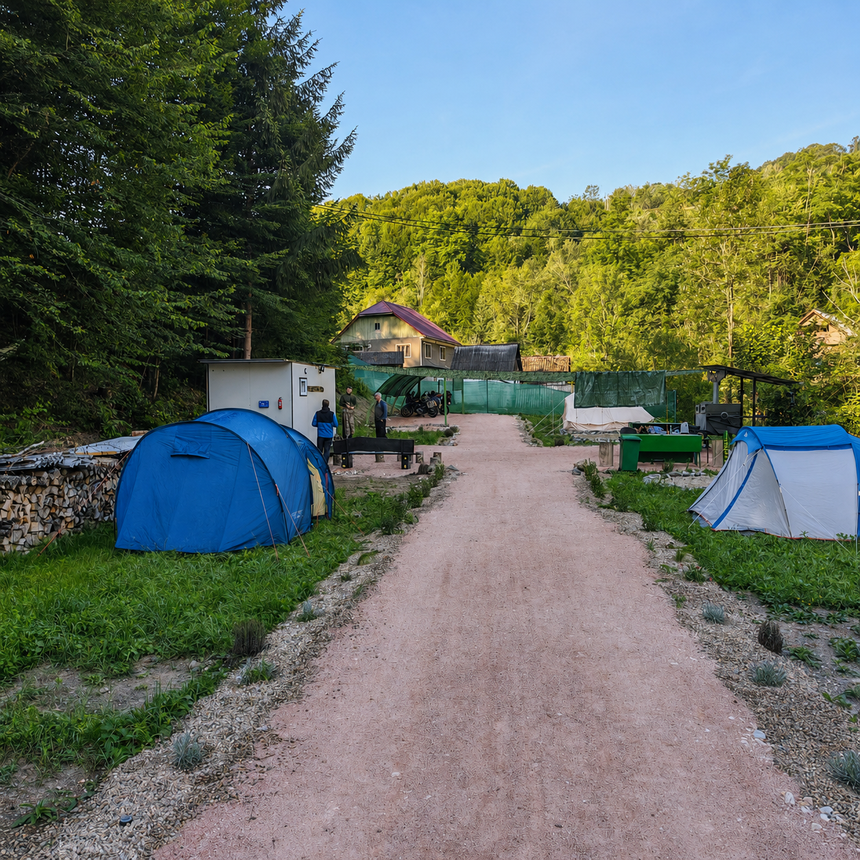 Aleea principala a campingului cu parcele de cort de o parte si de alta